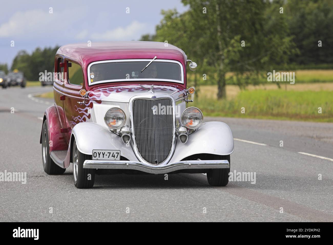 SOMERO, FINLANDIA, 5 AGOSTO 2017: Classica auto Hot Rod Ford con schema di fiamma magenta si muove lungo l'autostrada rurale sulla Maisemaruise 2017 a Tawa Foto Stock