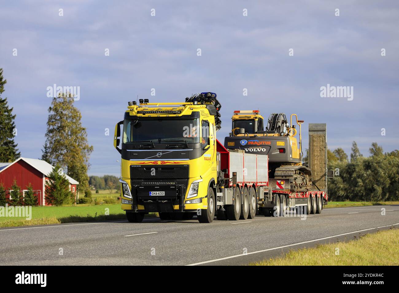 Il veicolo Volvo FH giallo personalizzato di Kankareen Paalutus Oy trasporta l'escavatore Volvo in una serata d'autunno soleggiata. Loimaa, Finlandia. 18 settembre 2020 Foto Stock