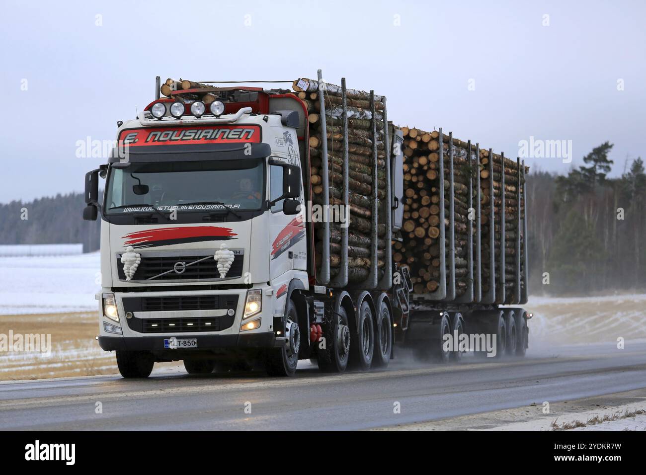 SALO, FINLANDIA, 20 GENNAIO 2017: Veicolo combinato Volvo FH bianco e rosso di Kuljetusliike e Nousiainen trasporta legno di pasta lungo l'autostrada bagnata Foto Stock