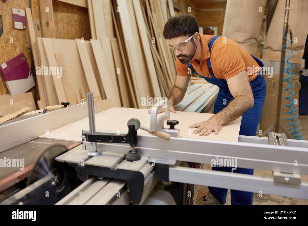 Artigiano che taglia legname su pezzi che lavorano su una piattaforma di taglio circolare Foto Stock