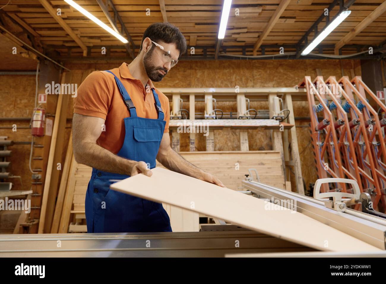 Artigiano che taglia legname su pezzi che lavorano su una piattaforma di taglio circolare Foto Stock