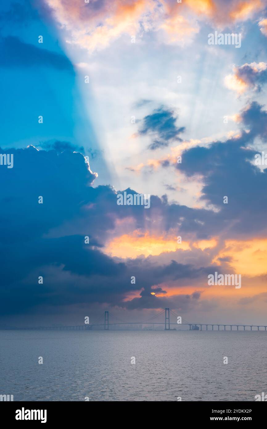 Attraversa il ponte sul mare all'alba con splendide nuvole a composizione verticale Foto Stock