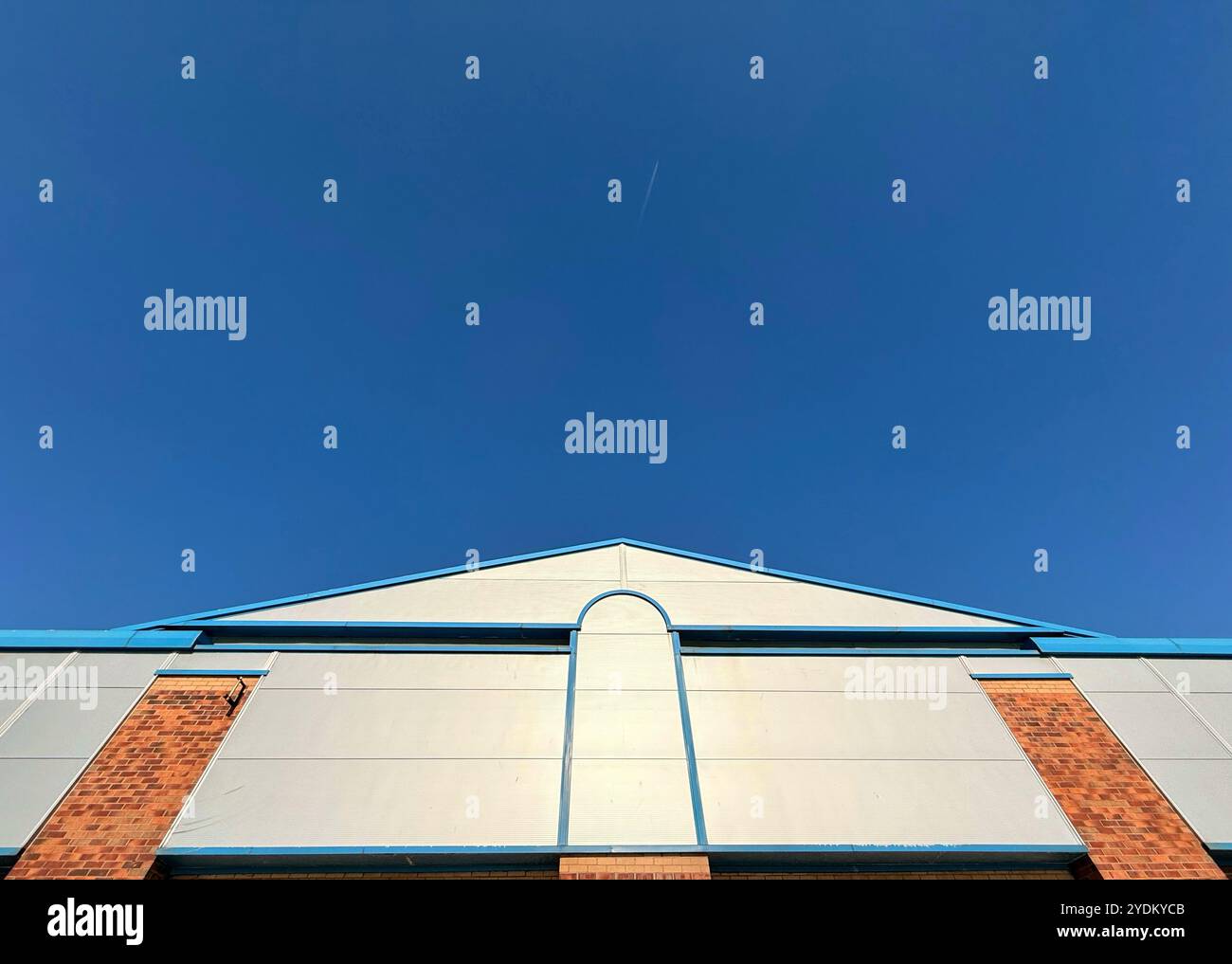 Dettaglio del negozio che sembra una freccia gigante che punta verso un cielo blu vuoto Foto Stock