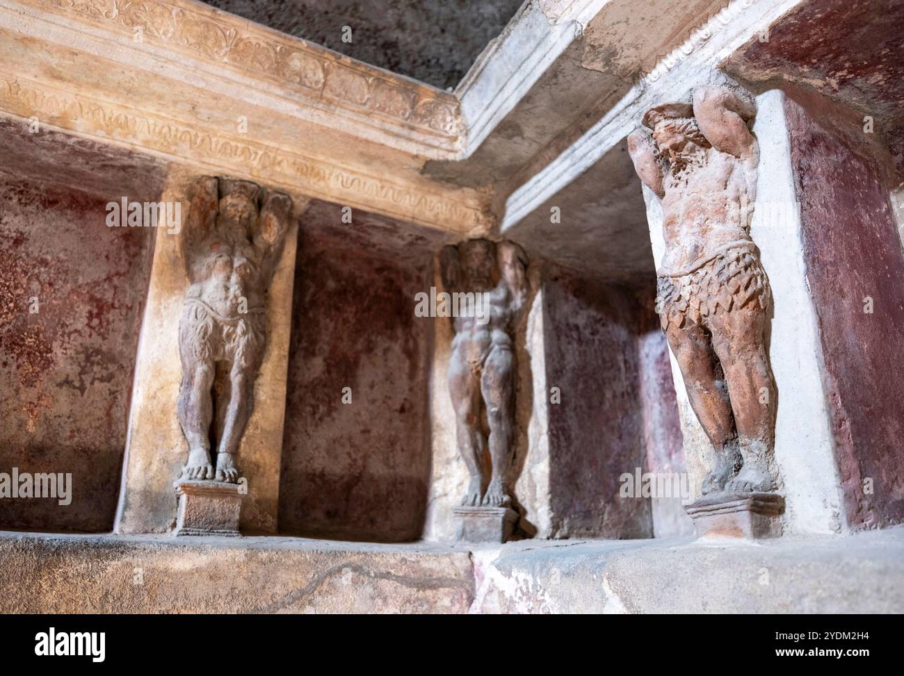 Statue in miniatura decorano le pareti all'interno di una casa termale di Pompei, parco archeologico di Pompei, Napoli Italia. Foto Stock