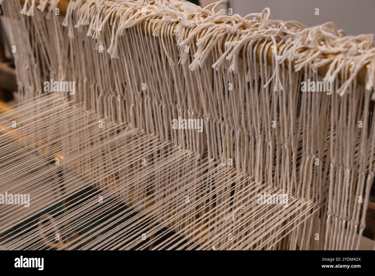 Primo piano delle filettature di un vecchio telaio in legno in un'officina a Isili Foto Stock