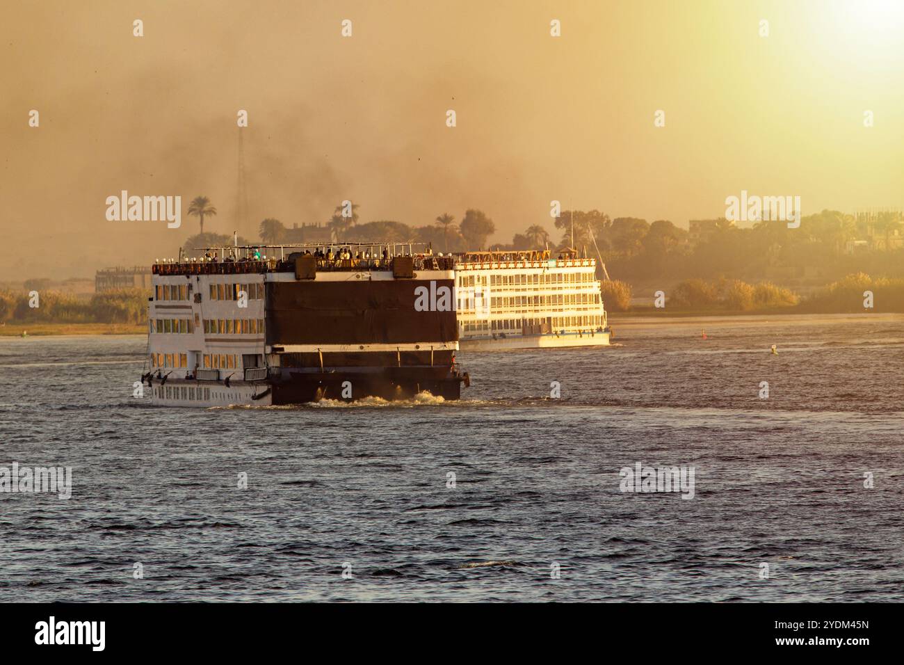 Unisciti a noi per un'indimenticabile avventura in crociera al tramonto sul Nilo di Assuan. Esplora le meraviglie dell'antico Egitto mentre ti rilassi con la nostra lussuosa crociera Foto Stock