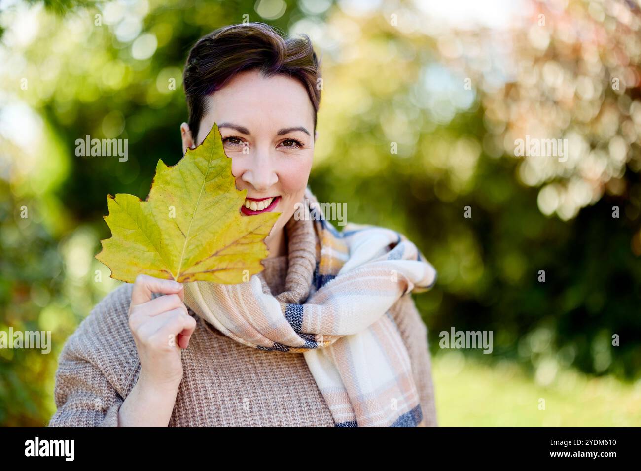 Donna che mantiene Foglie di autunno Foto Stock