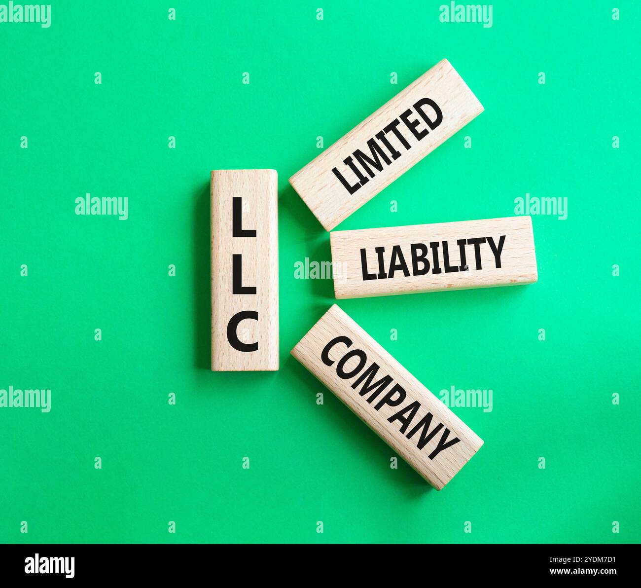 LLC - società a responsabilità limitata. Cubi in legno con parola LLC. Bellissimo sfondo verde. Business e LLC. Copia spazio. Foto Stock