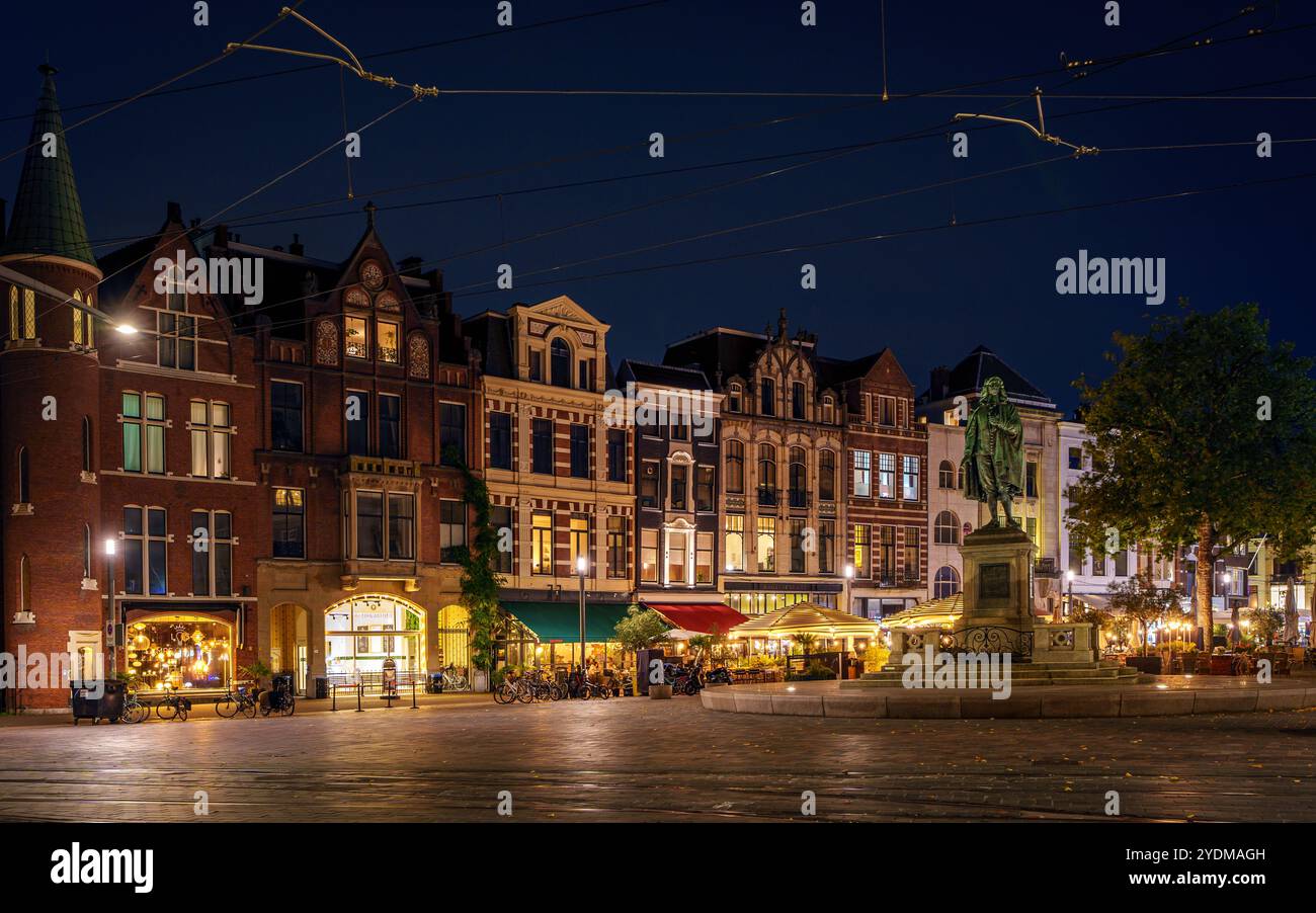 Una tranquilla vista serale della storica piazza dell'Aia, con edifici splendidamente illuminati e accoglienti caffetterie sotto un cielo stellato. Foto Stock