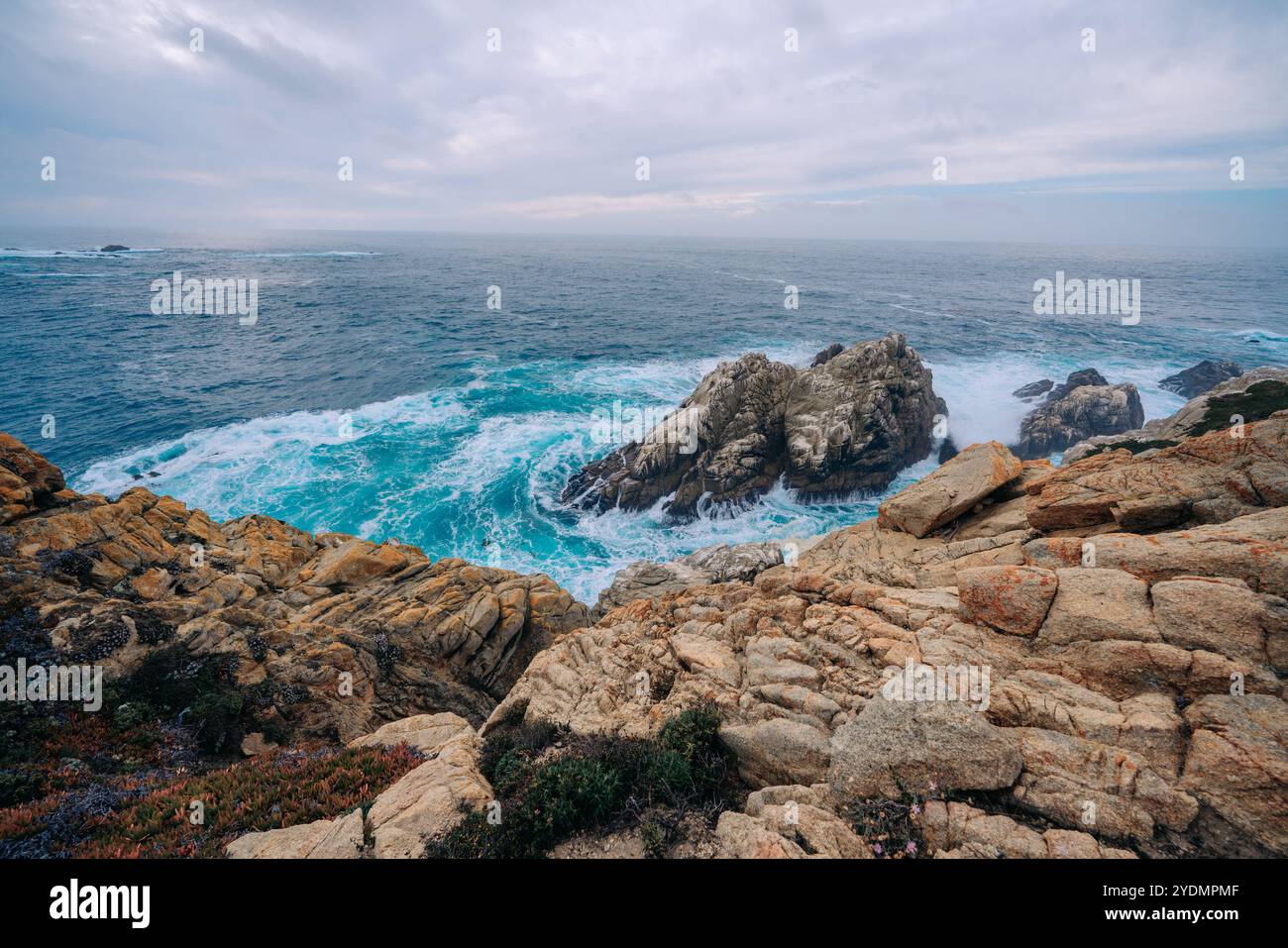Vista sulla spiaggia rocciosa e sull'oceano in una giornata di maltempo Foto Stock