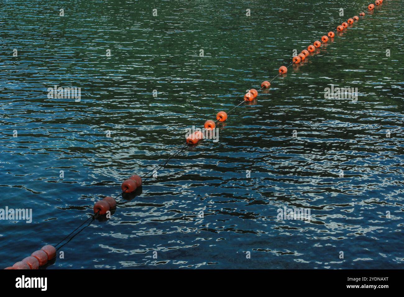 I bracci di barriera sull'acqua sotto forma di galleggianti su una fune allungata Foto Stock
