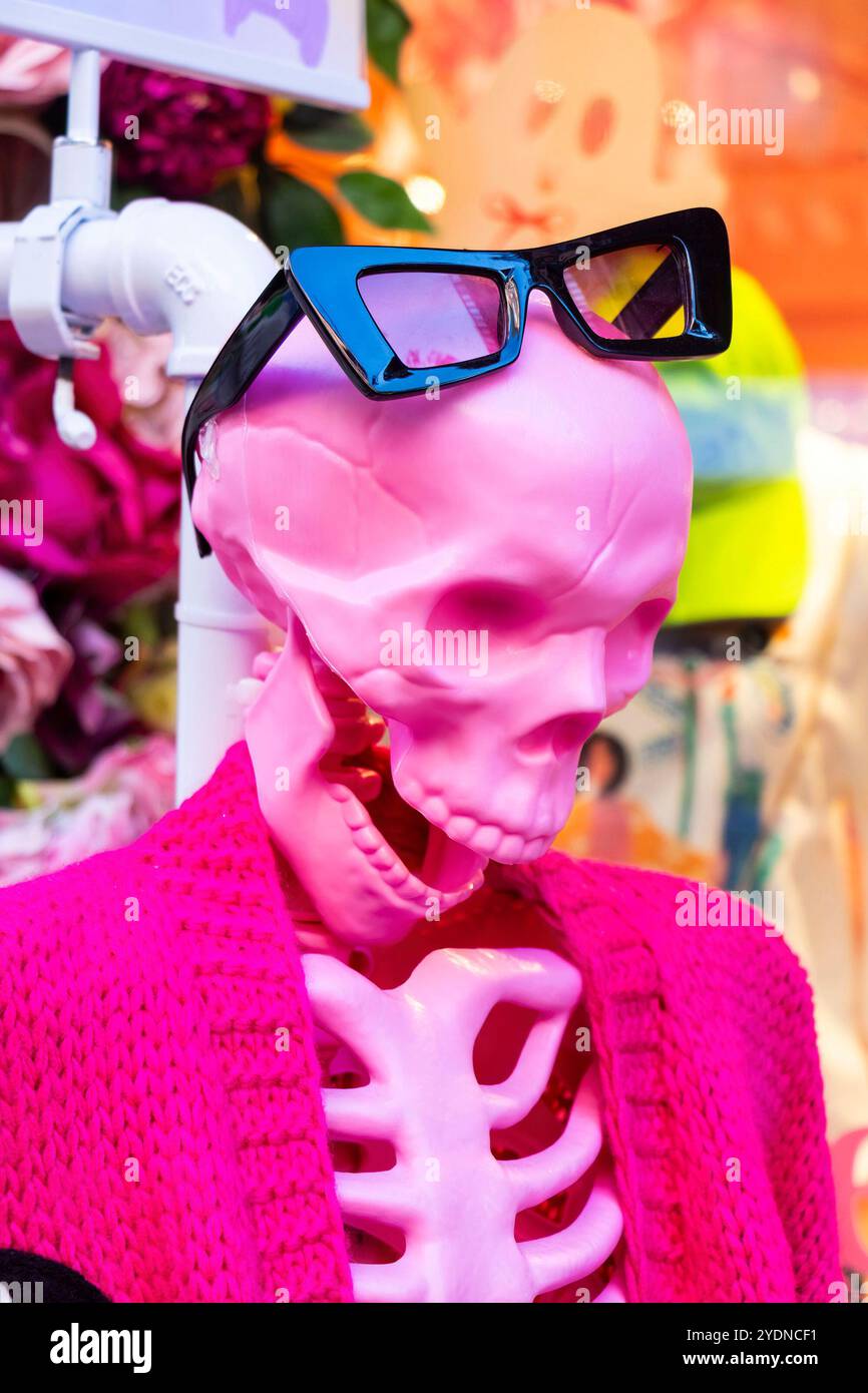 Uno scheletro di manichino rosa che indossa eleganti occhiali da sole neri e una vivace giacca rosa in un colorato negozio urbano che espone nyc usa Foto Stock