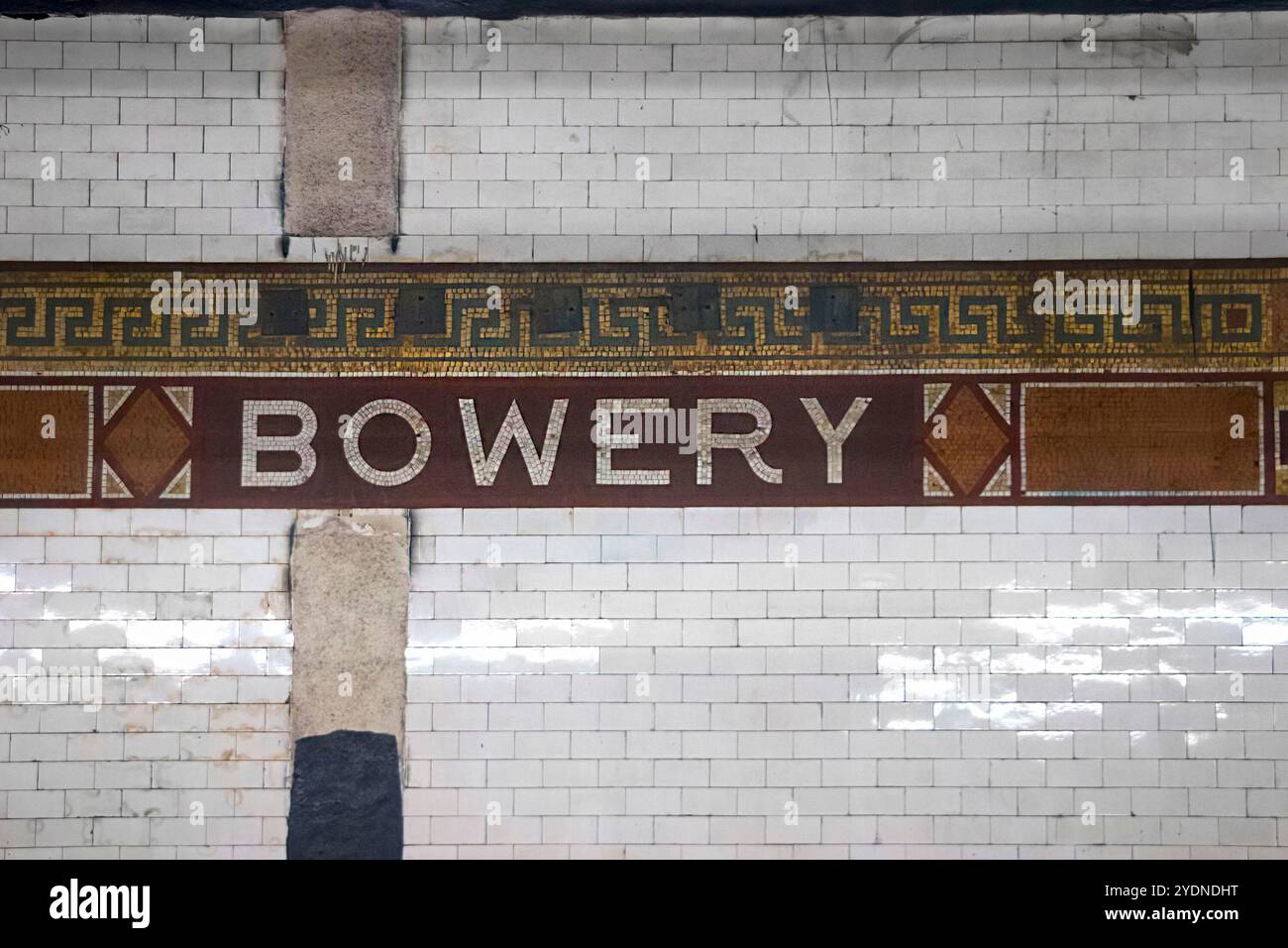 Opere d'arte in mattonelle della metropolitana d'epoca con il nome Bowery in un mosaico decorato su una parete di mattoni bianchi Foto Stock