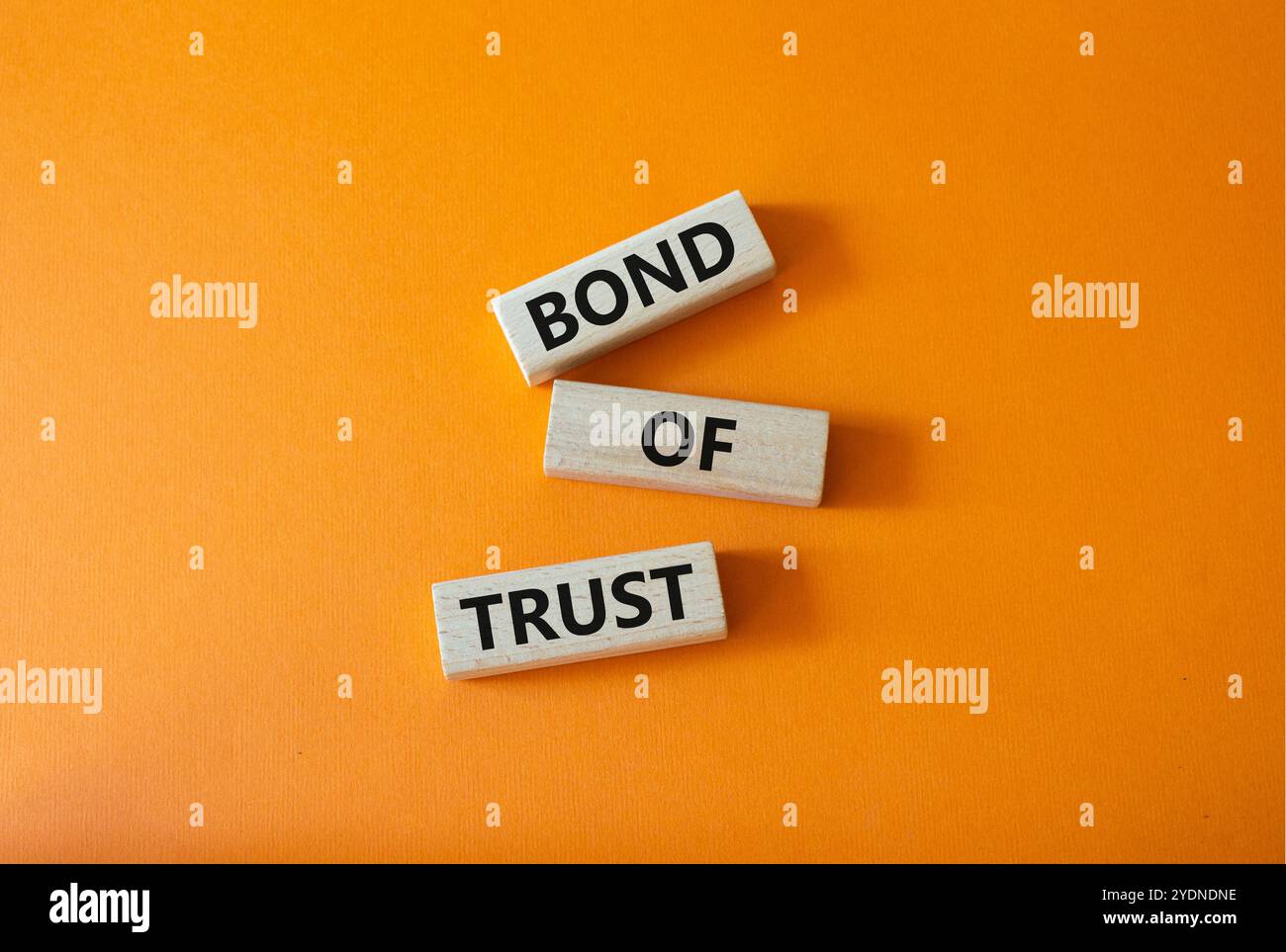 Simbolo del legame di fiducia. Blocchi di legno con parole Bond of Trust. Bellissimo sfondo arancione. Business e Bond of Trust. Copia spazio. Foto Stock