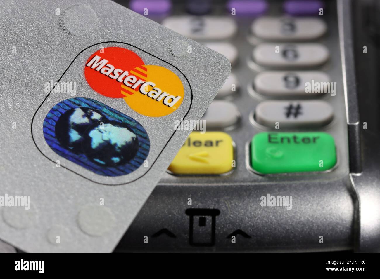 Logo MasterCard sulla carta di credito con terminale di pagamento sullo sfondo Foto Stock