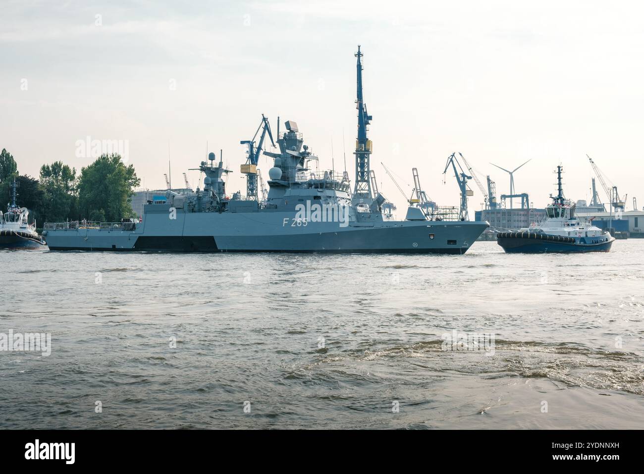 Amburgo, Germania - 04.09.2024: La nave da guerra della marina tedesca viene rimorchiata nel porto di Amburgo per la manutenzione da due rimorchiatori. Foto Stock