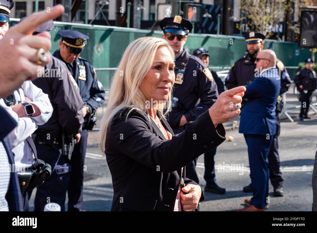 New York, New York, Stati Uniti. 27 ottobre 2024. Folle di sostenitori di Donald Trump, molti con berretti e camicie marchiati MAGA o Trump, si riuniscono fuori dal Madison Square Garden prima di un raduno serale. La rappresentante della Georgia Marjorie Taylor Green posa per alcuni selfie sulla 8th Avenue. Crediti: Ed Lefkowicz/Alamy Live News Foto Stock