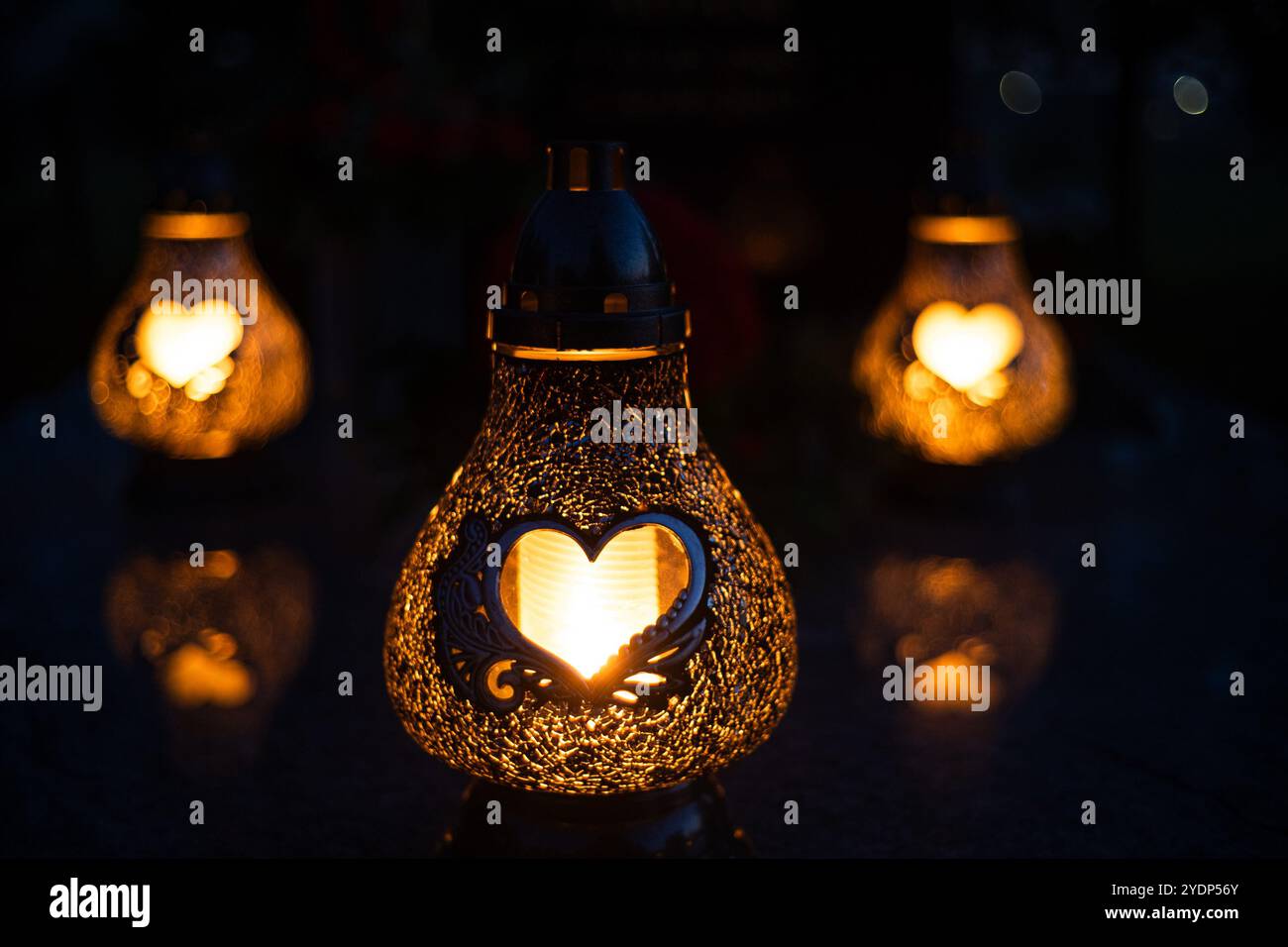 Candele a forma di cuore accese su una tomba il giorno di Ognissanti Foto Stock