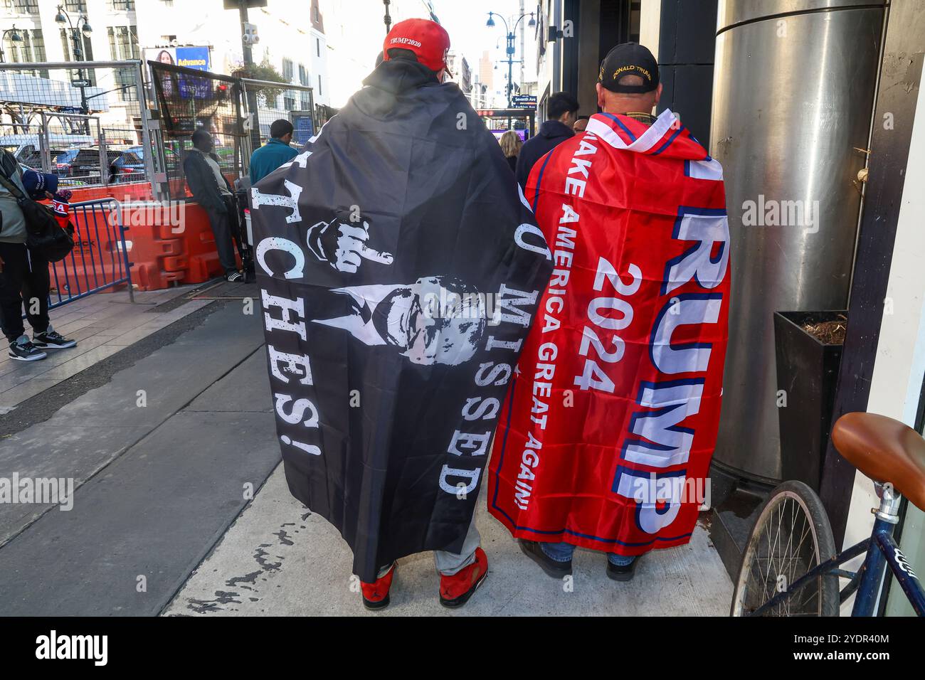 Due uomini che non hanno rivelato i nomi indossano bandiere a sostegno di Donald Trump posano per una foto prima di una manifestazione elettorale per il candidato presidenziale repubblicano, l'ex presidente Donald Trump al Madison Square Garden di New York, N.Y., domenica 27 ottobre 2024. (Foto: Gordon Donovan) Foto Stock