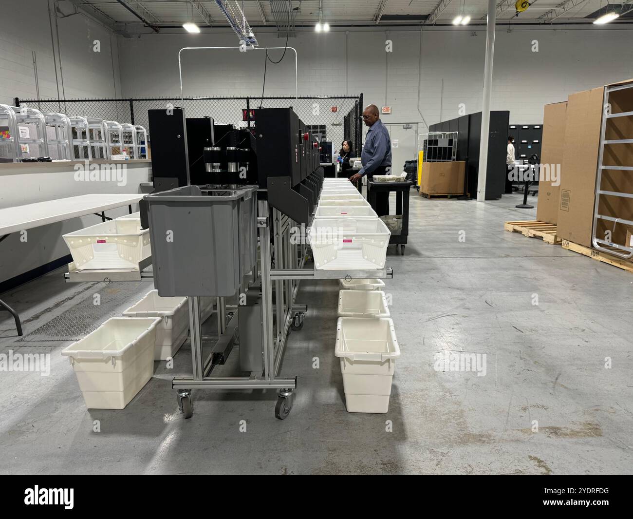 Lawrenceville, Stati Uniti. 23 ottobre 2024. Un addetto ai sondaggi aggira le schede assentee in una stazione elettorale nella contea di Gwinnett, in Georgia, in preparazione delle elezioni presidenziali statunitensi. Le elezioni presidenziali degli Stati Uniti si svolgeranno il 5 novembre 2024. Crediti: Luzia Geier/dpa/Alamy Live News Foto Stock