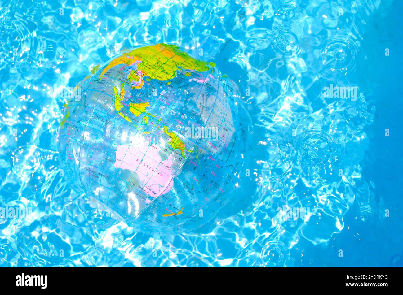 Palla da spiaggia a forma di terra che galleggia sulla superficie dell'acqua Foto Stock