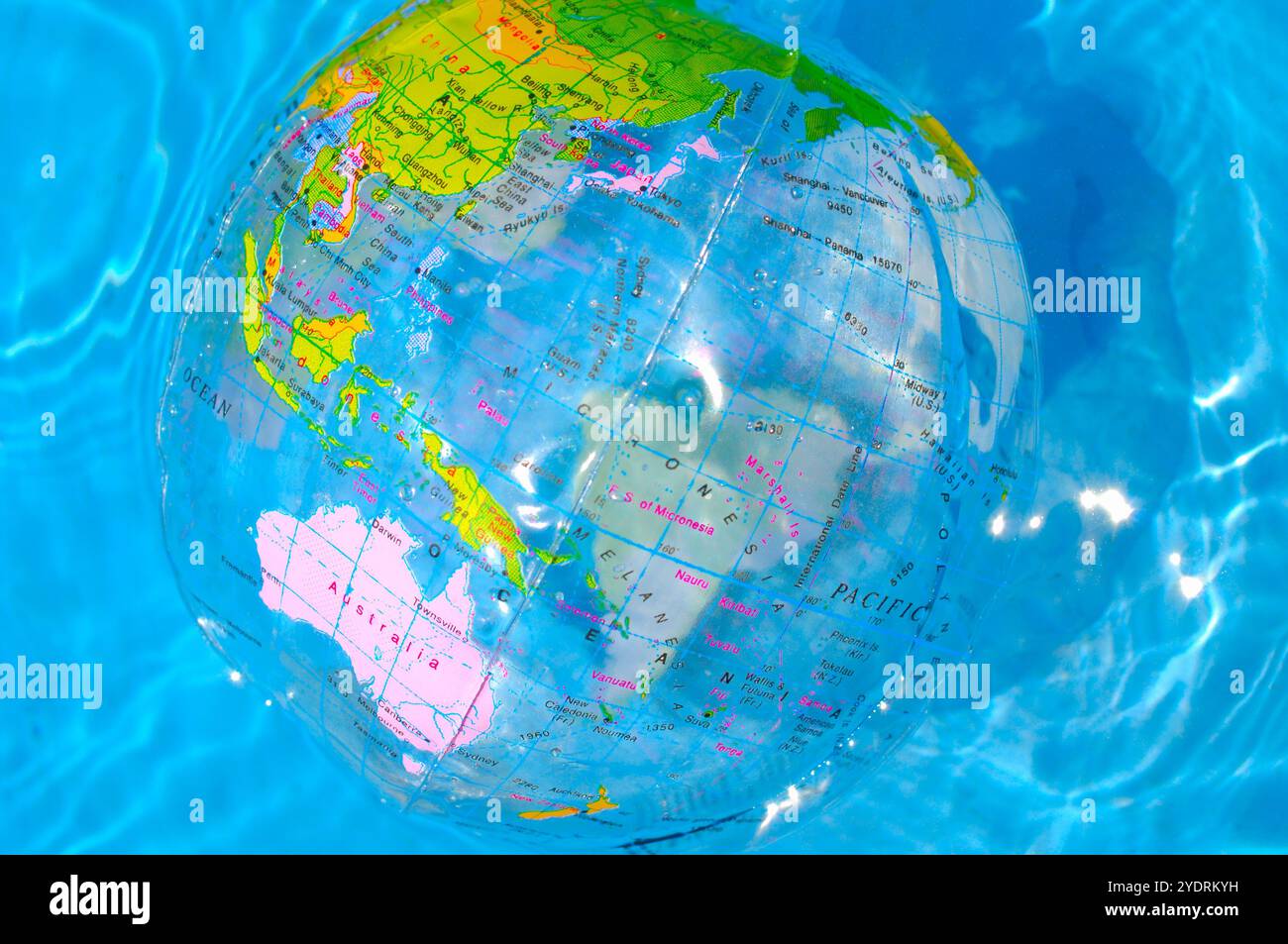 Palla da spiaggia a forma di terra che galleggia sulla superficie dell'acqua Foto Stock