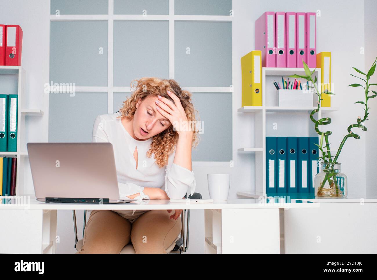 Donna d'affari overworked che soffre di mal di testa e pensare come terminare il lavoro. Stanco lavoratore d'ufficio. Donna ragazza che annoia in ufficio. Foto Stock