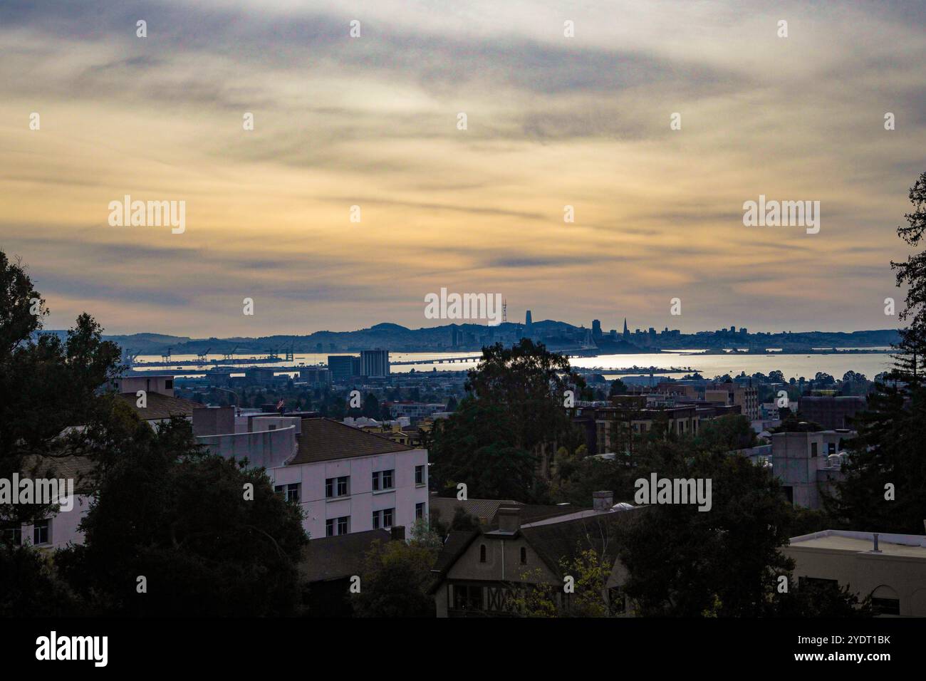 Vista sul crepuscolo della collina che guarda attraverso la città di Berkeley al Bay Bridge e a San Francisco. Foto Stock