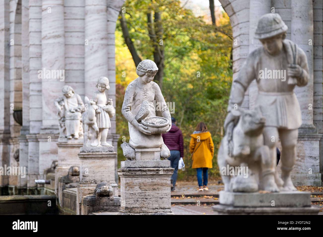 Besucher am Märchenbrunnen im Berliner Stadtteil Friedrichshain an einem Herbsttag. Der Märchenbrunnen ist Umgeben von Figutes der Märchen der Gebrüder Grimm. / I visitatori della fiaba fontana nel quartiere Friedrichshain di Berlino in un giorno d'autunno. La fontana delle fiabe è circondata da statuette delle fiabe dei Fratelli Grimm. Fotografia istantanea/K.M.Krause *** visitatori alla fontana fiabesca nel quartiere Friedrichshain di Berlino in un giorno d'autunno la fontana fiabesca è circondata da statuette dei visitatori delle fiabe Brothers Grimm presso la fontana fiabesca di Berlino Friedrichsha Foto Stock