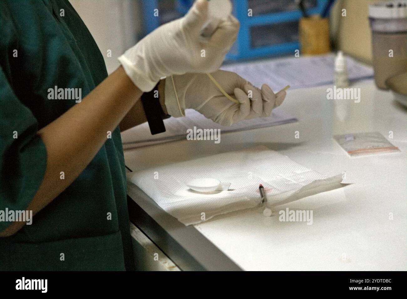 Un veterinario prepara una dose di farmaco, prima di dare un trattamento medico a un loris lento che è stato salvato dal commercio di fauna selvatica. Foto Stock