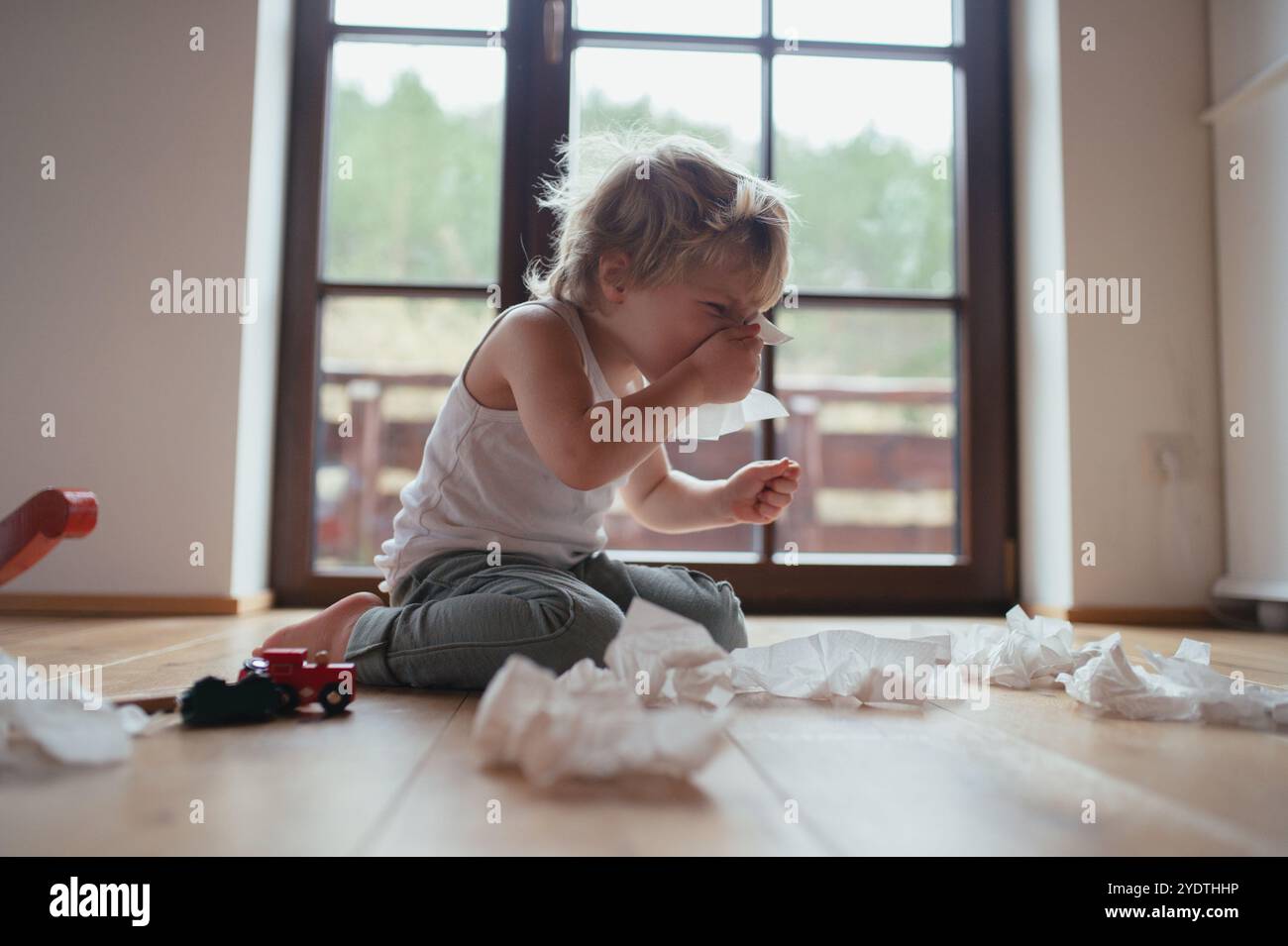 Il ragazzo malato con il freddo ha il naso soffocato e soffia il naso. Foto Stock