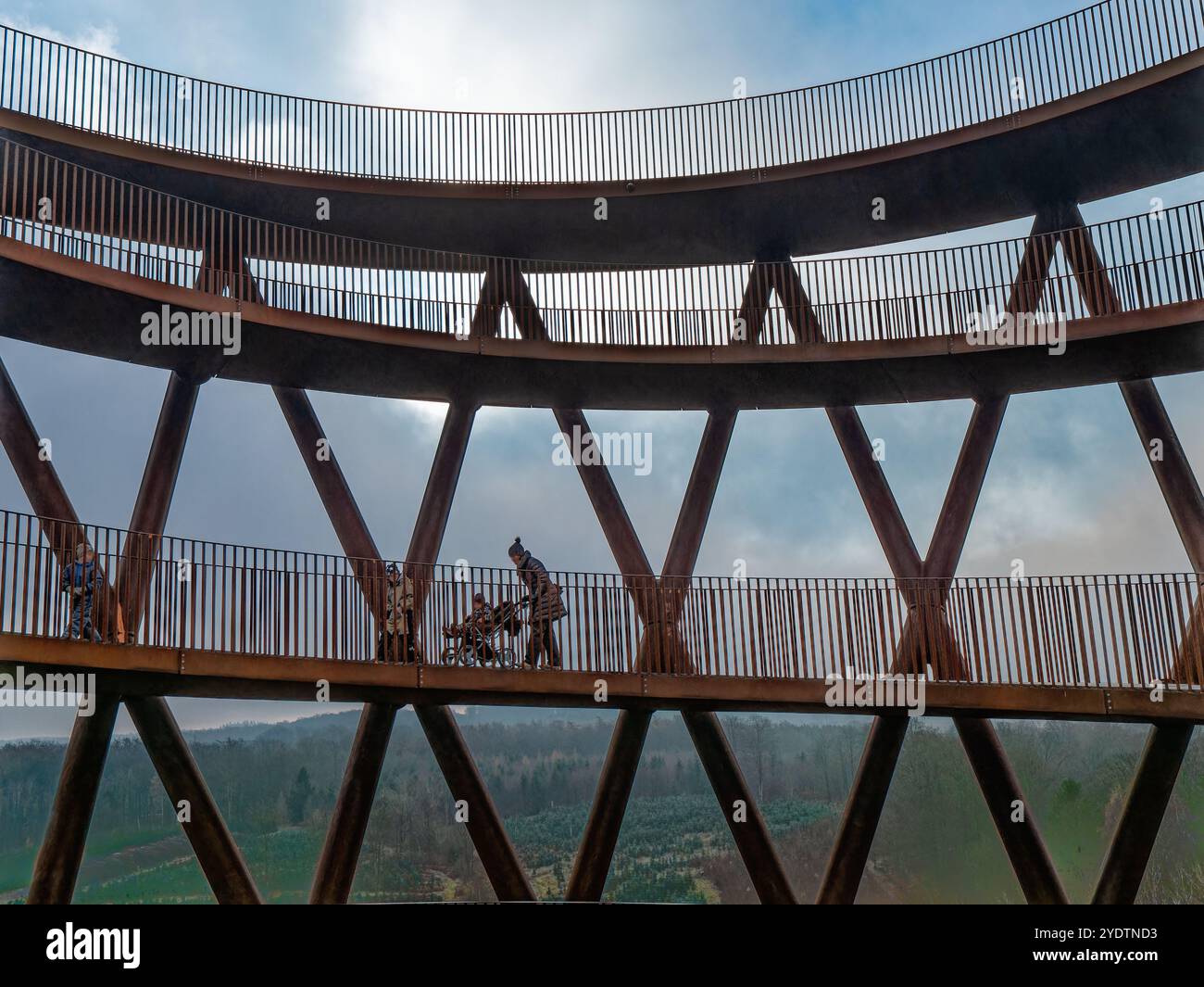 Una suggestiva torre di osservazione in legno a forma di spirale adagiata su un cielo blu limpido, circondata da alberi senza fronzoli. Cattura l'innovazione architettonica e Foto Stock