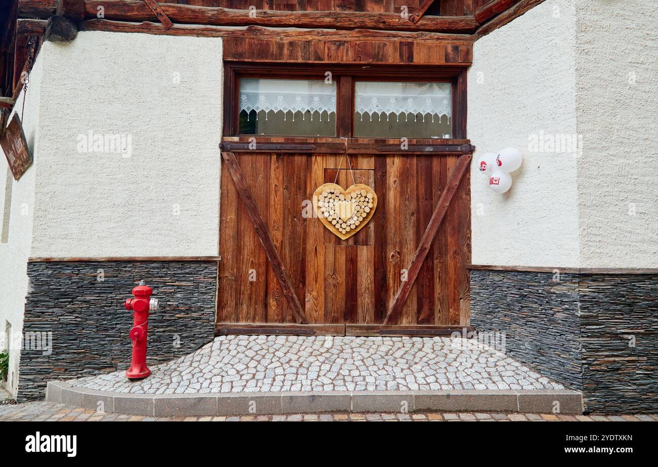 Porta in legno decorata con un cuore, da un'enoteca in Val di Sole Foto Stock