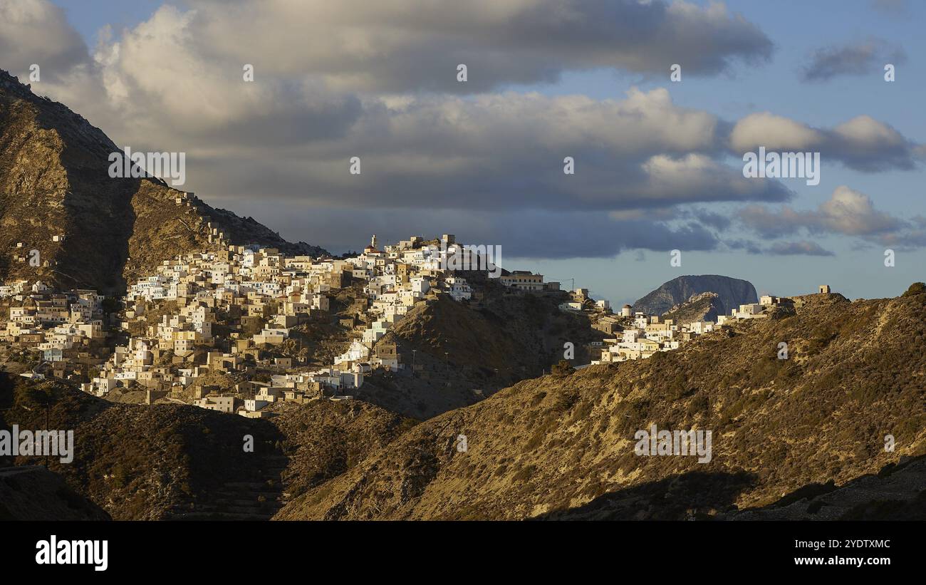 Un'ampia vista sul villaggio tra le montagne sotto un suggestivo cielo nuvoloso, un colorato villaggio di montagna, la luce del mattino, Olymbos, Karpathos, Dodecaneso, GRE Foto Stock