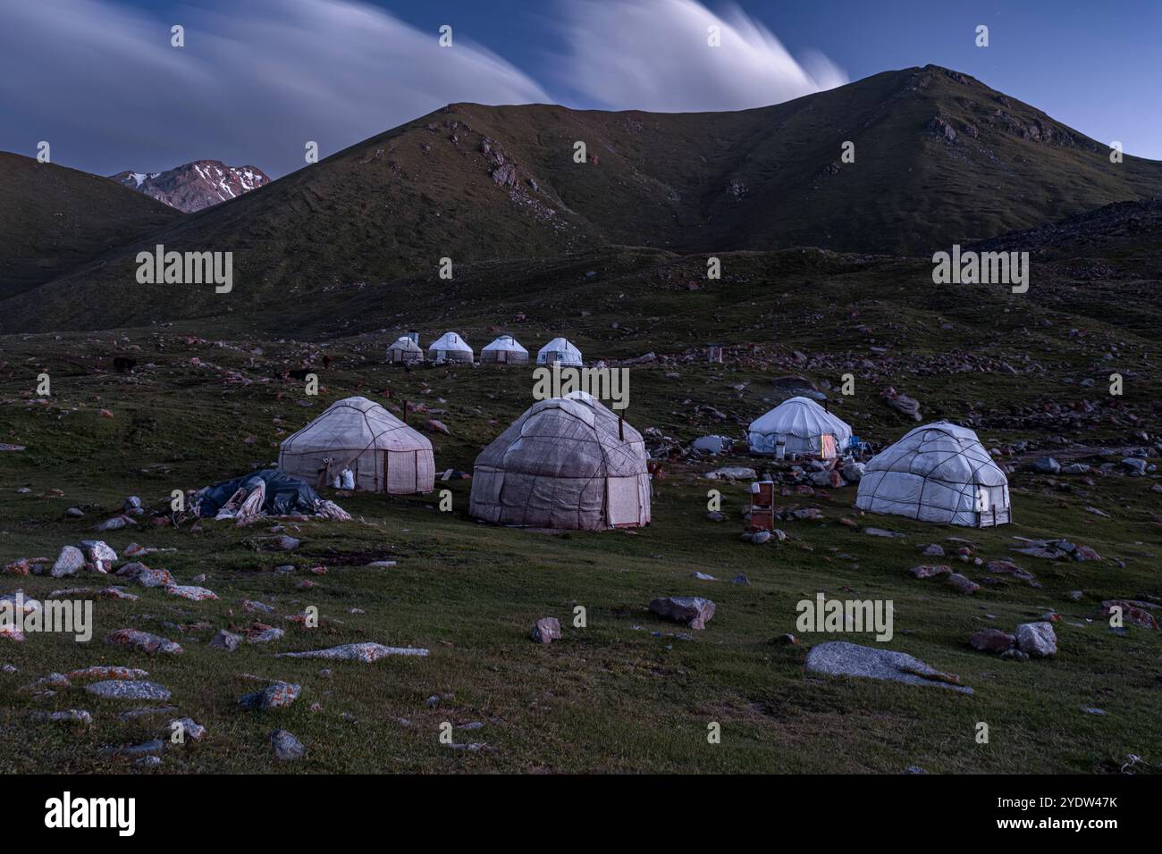 Le yurte sono splendidamente disposte sulle montagne intorno al lago Kol-Ukok al crepuscolo, mettendo in risalto lo stile di vita nomade culturale, il Kirghizistan e l'Asia centrale Foto Stock