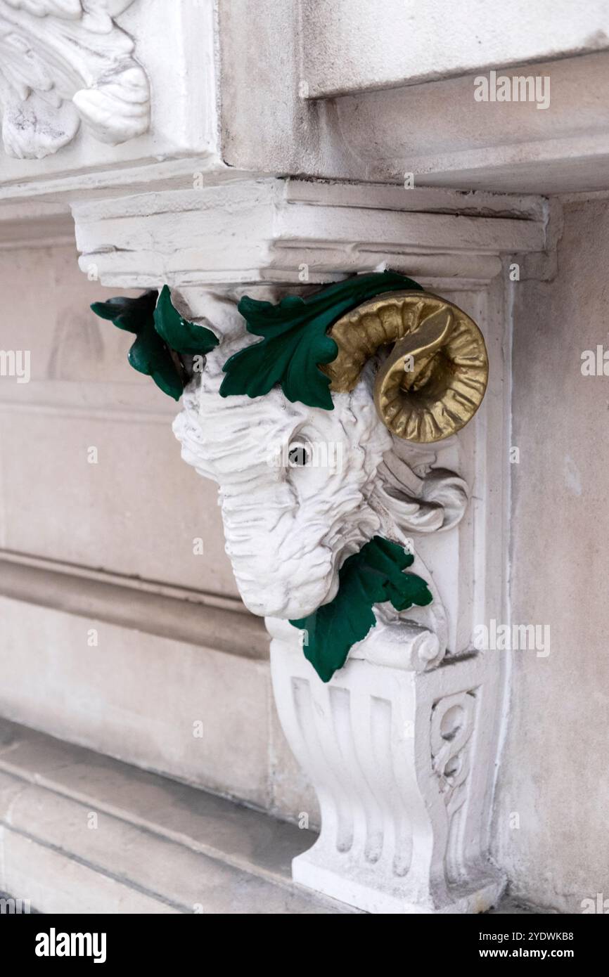 La scultura della testa di RAM con corna dorate lascia dettagli architettonici verdi sul lato di un edificio nella City di Londra Inghilterra Regno Unito KATHY DEWITT Foto Stock