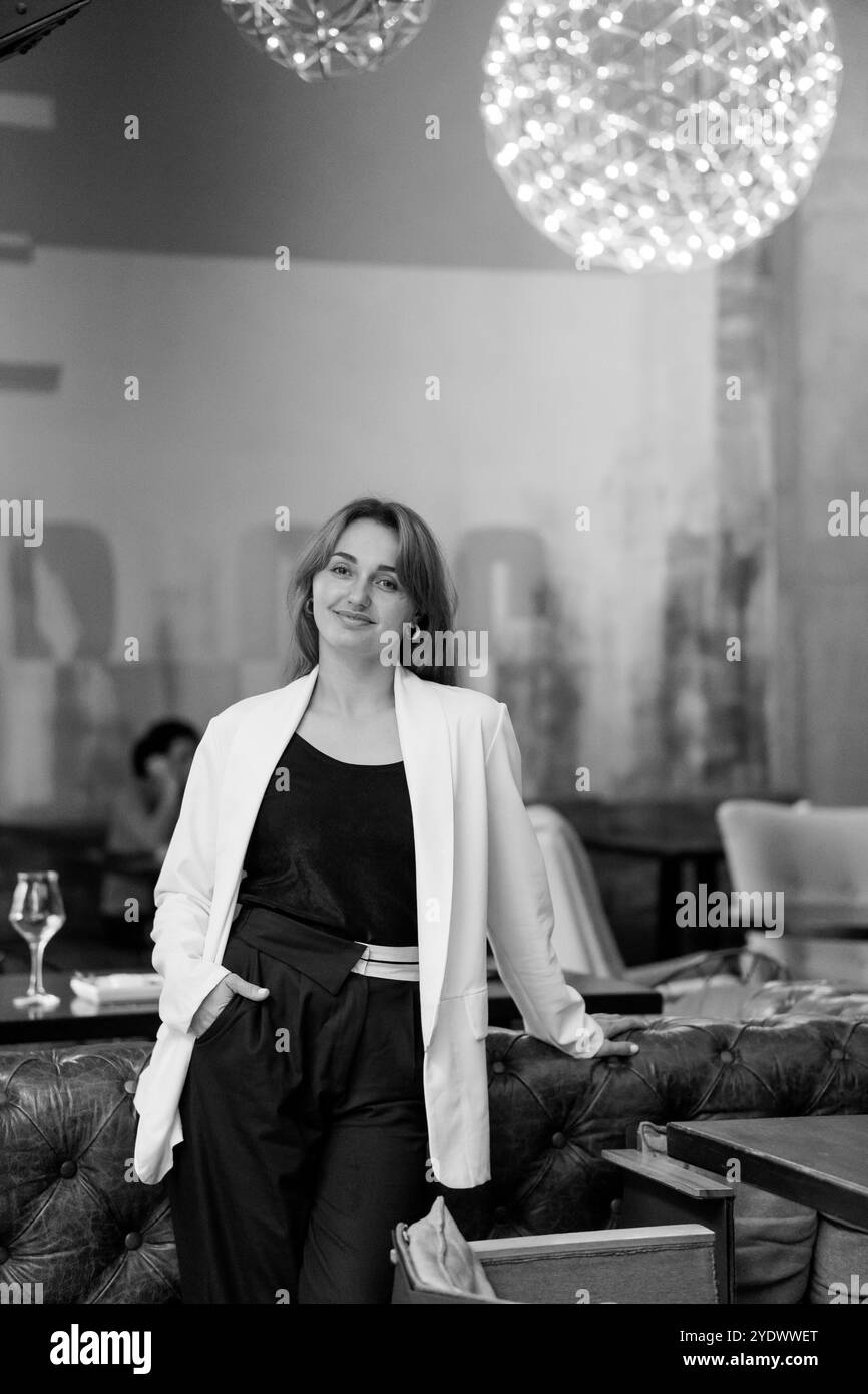 Donna elegante in un elegante ambiente da ristorante. Foto Stock