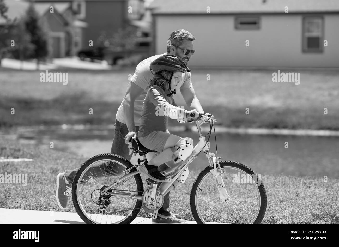 Giorno dei padri. Ragazzo imparando a fare una bicicletta con il padre nel parco. Padre insegna a suo figlio in bicicletta. Padre impara piccolo figlio a cavalcare un Foto Stock