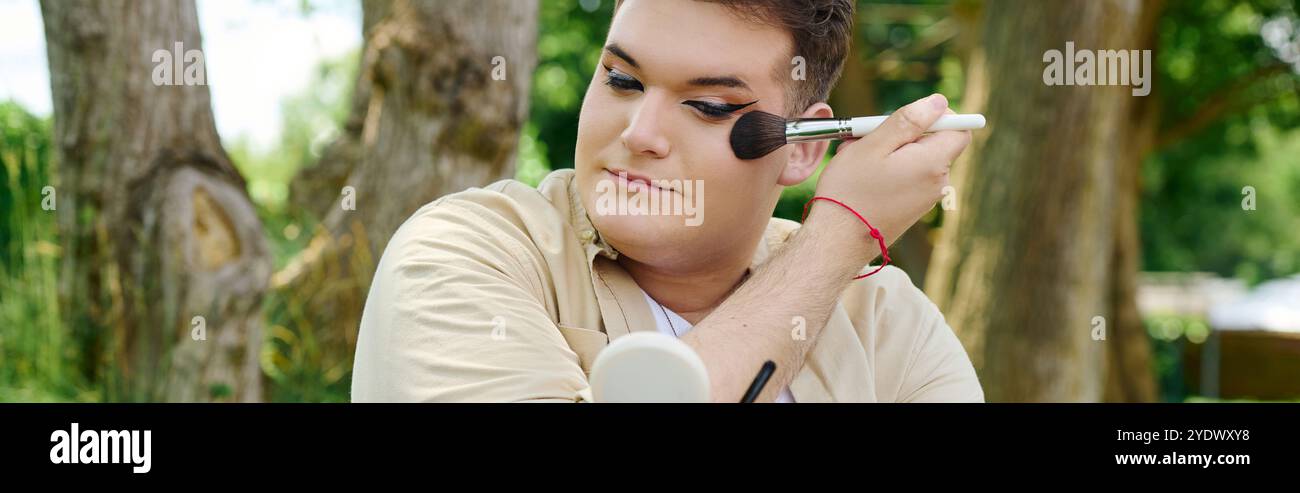 In un ambiente tranquillo all'aperto, un individuo applica sapientemente il trucco con un'espressione mirata. Foto Stock