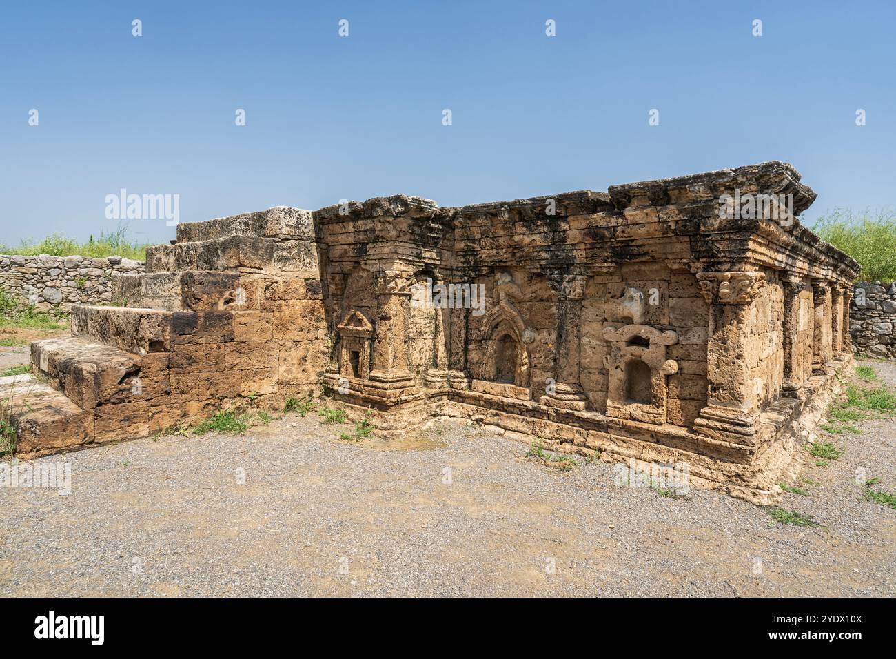 Vista laterale dell'antico stupa a doppia testa di aquila nelle rovine di Sirkap, Taxila, Punjab, Pakistan, patrimonio dell'umanità dell'UNESCO Foto Stock