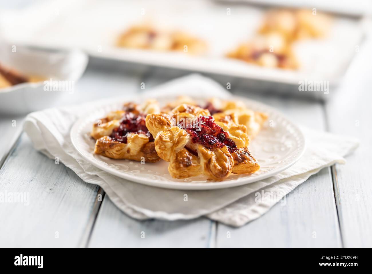 Dolci dolci di pasta sfoglia con marmellata di fragole ripieni di mele caramellate. Foto Stock