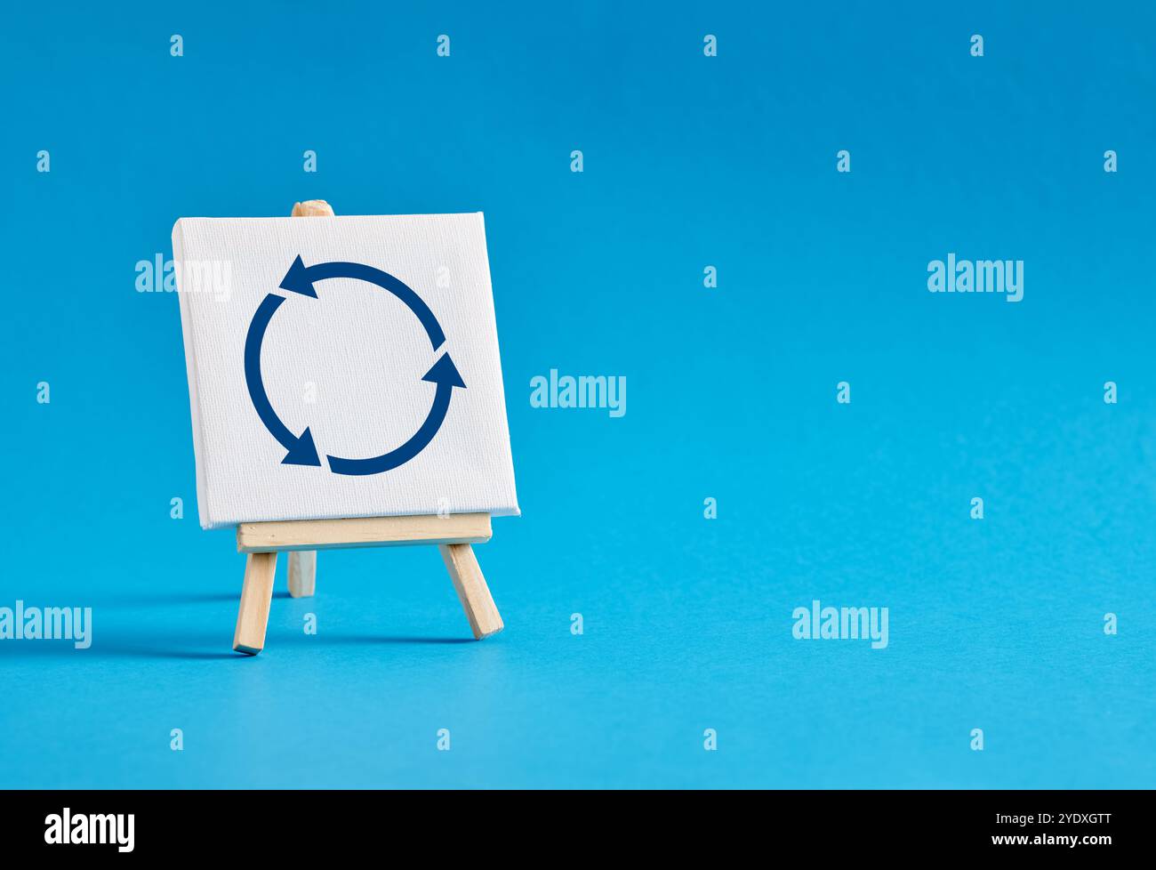 Cavalletto con simbolo delle frecce rotanti su sfondo blu. Ricarica, aggiorna, rotazione, rotatoria o ciclo vizioso. Stagnazione o riciclo economico o commerciale Foto Stock