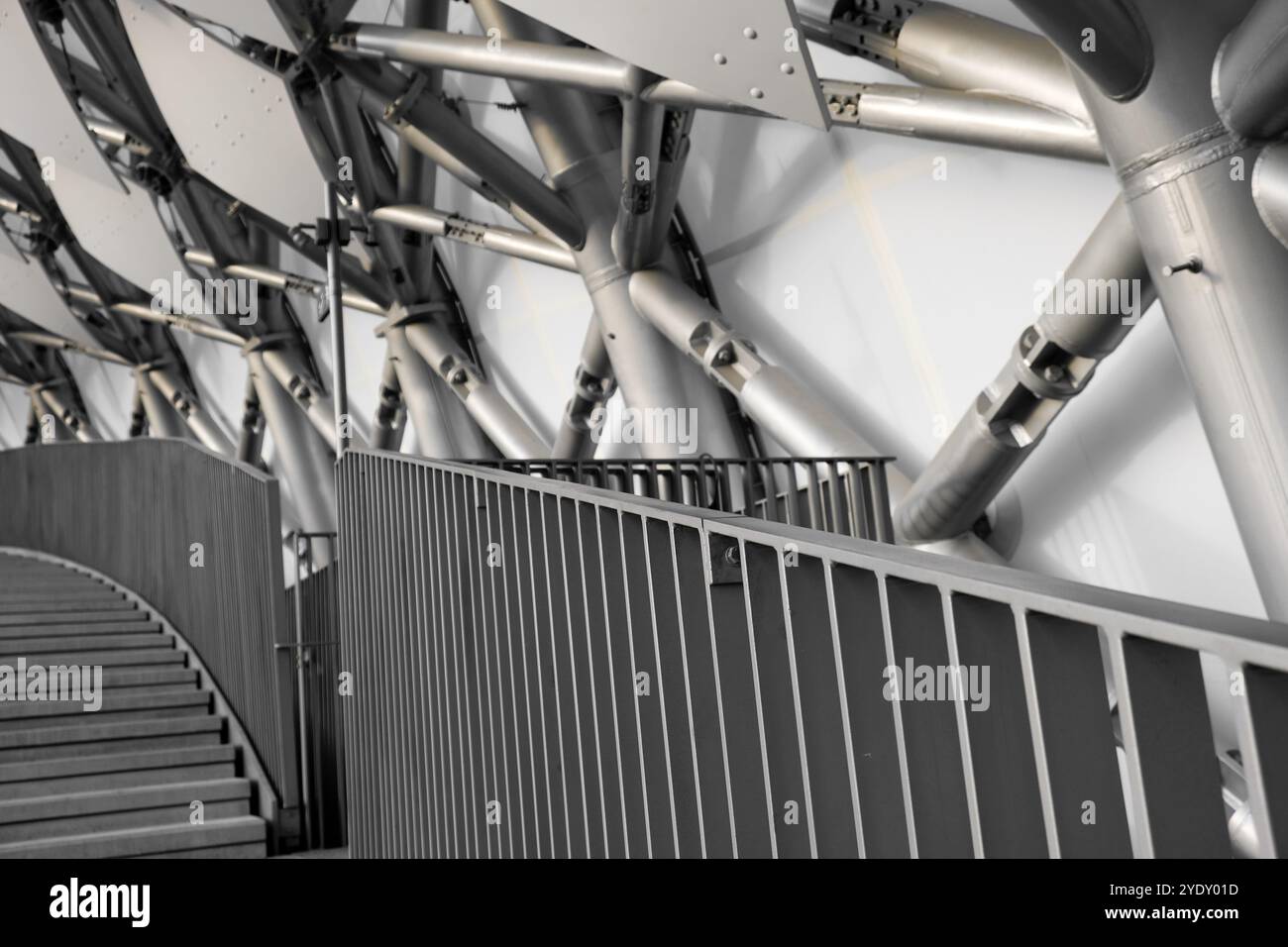 La vista interna mostra un'elegante disposizione di supporti metallici e intricate ringhiere a scala, mettendo in risalto il design architettonico moderno Foto Stock