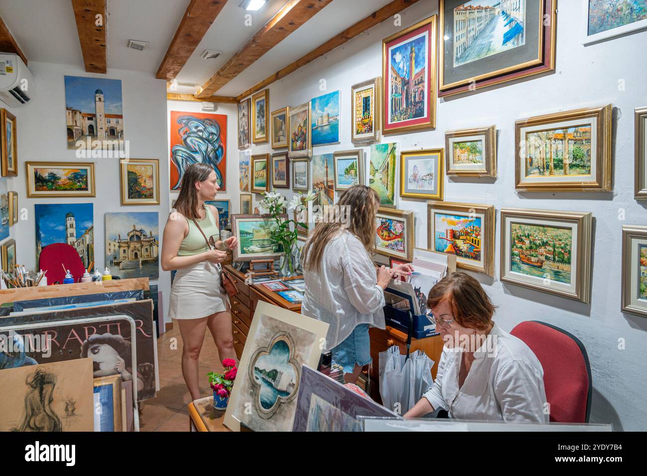 Dubrovnik Croazia, città vecchia di Stari Grad, città murata di Ragusa, turisti turisti, donne che fanno shopping, opere d'arte piccoli dipinti, vendita di soggetti locali, insi Foto Stock