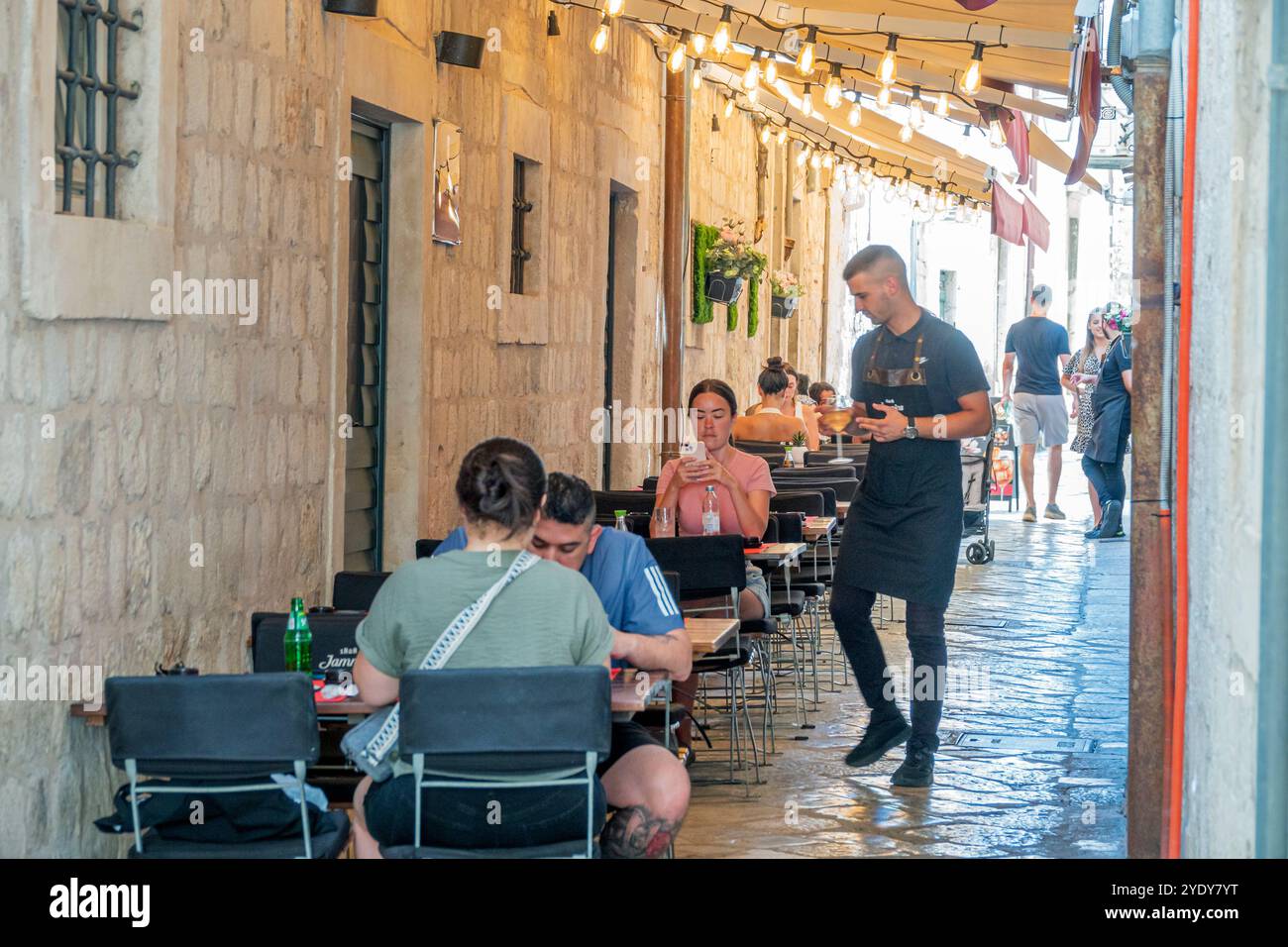 Dubrovnik Croazia, città Vecchia di Stari Grad, città murata di Ragusa, caffetteria, ristorante all'aperto, uomini e donne coppie, uomo cameriere, turisti, C. Foto Stock