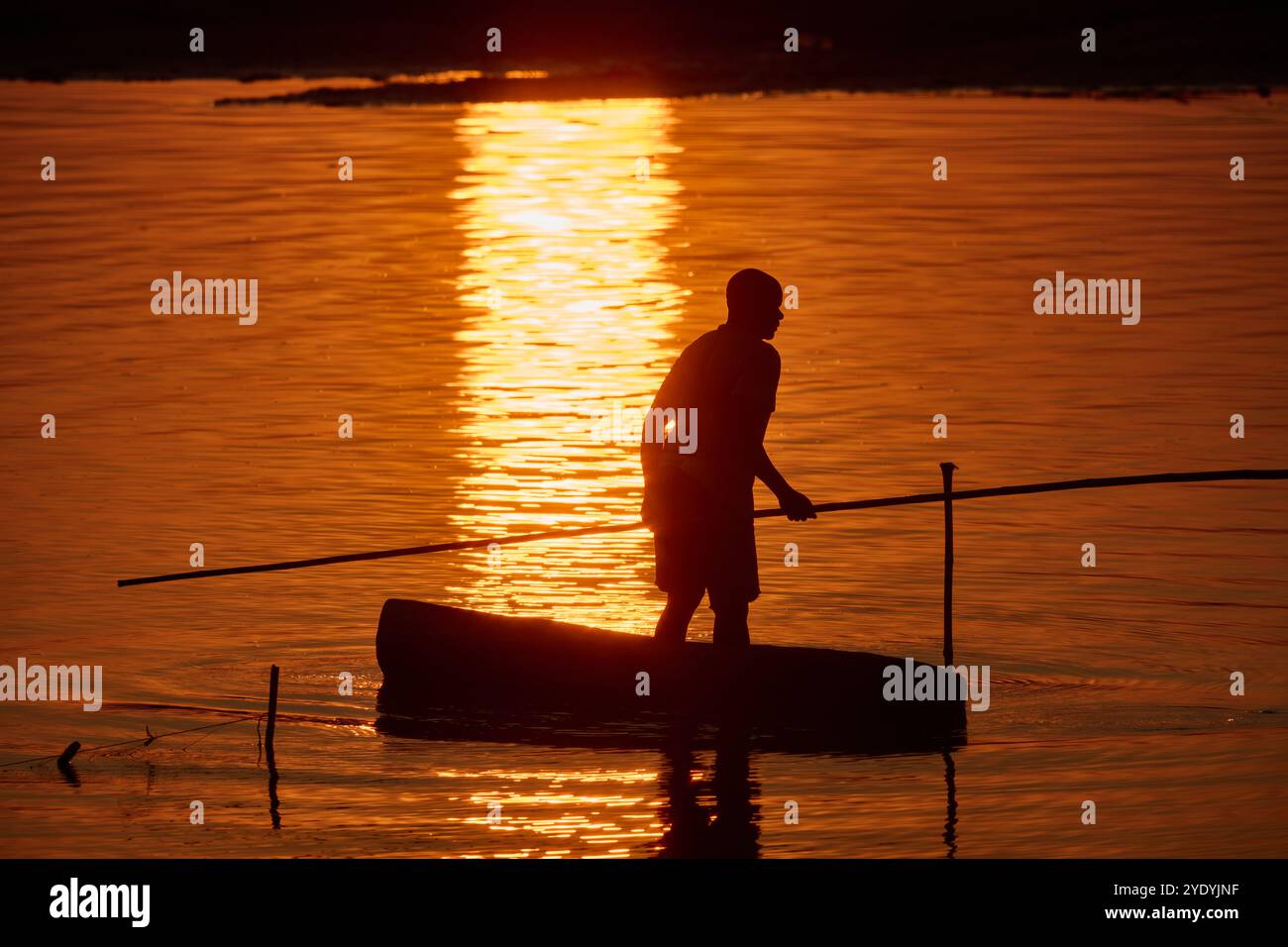 Pescatore in canoa sul fiume Luangwa al tramonto, South Luangwa National Park, Mfuwe, Zambia, Africa Foto Stock