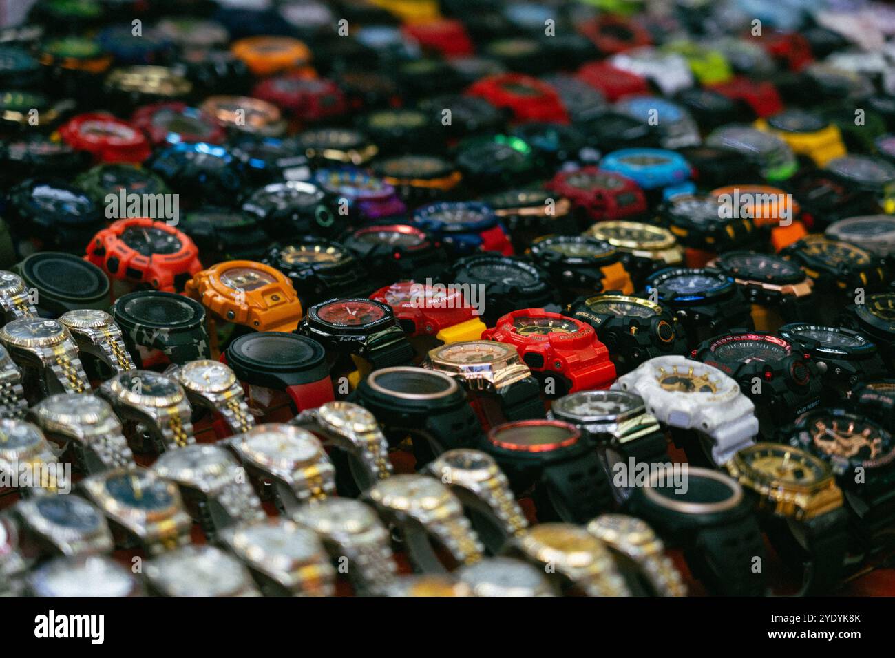 Una mostra di vari orologi in un mercato a Jalan Petaling, Kuala Lumpur. Gli orologi sono disposti in righe e sono di colori e stili diversi. Foto Stock