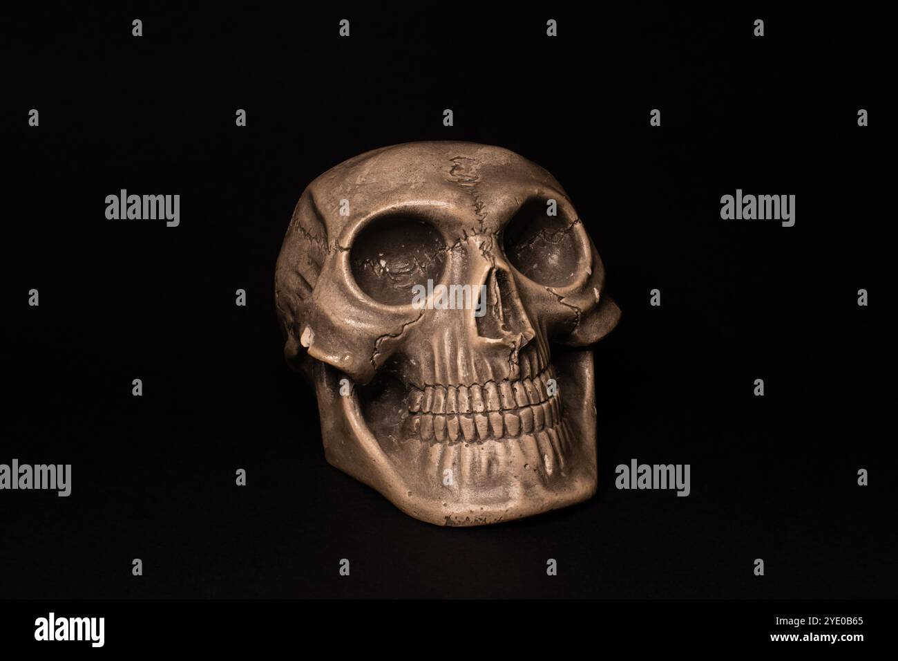 Felice scultura del cranio umano su sfondo nero, memento mori e concetto di morte Foto Stock