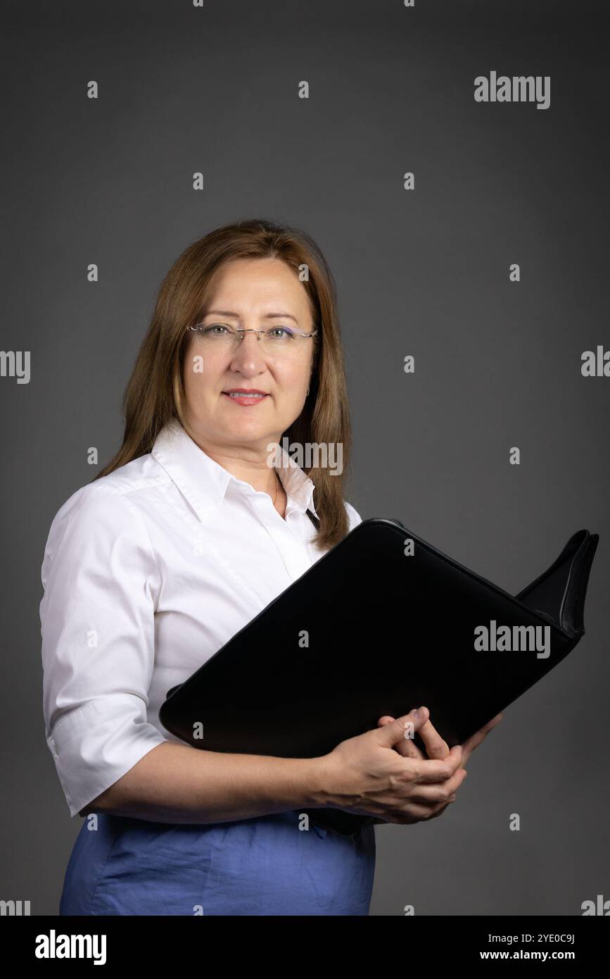 Ritratto di una donna professionale matura che tiene in mano un raccoglitore di documenti Foto Stock