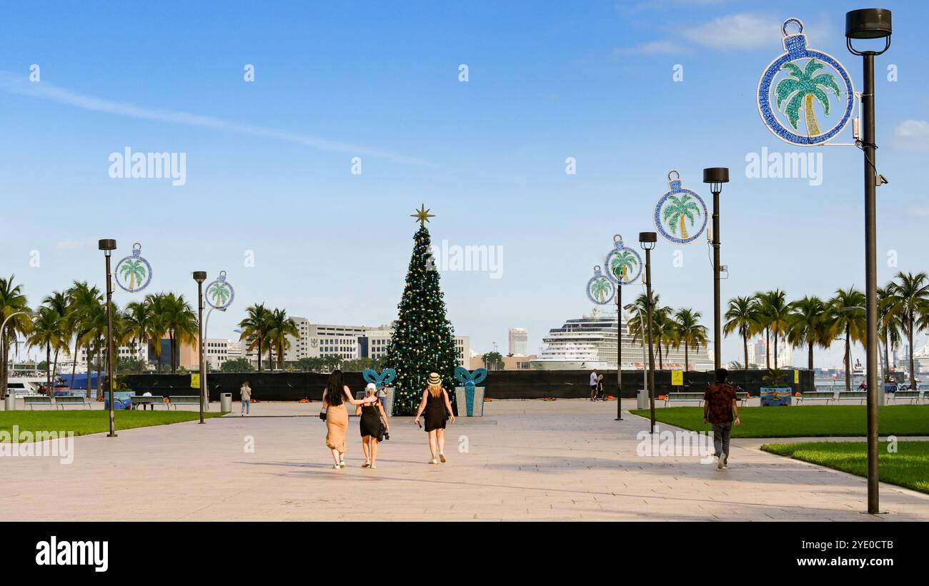 Miami, Florida, Stati Uniti - 3 dicembre 2023: Persone che passeggiano nel Bayfront Park, decorato con luci natalizie e un albero Foto Stock